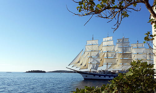 white and black boat on blue body of water under blue sky thumbnail