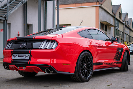 red and black Ford Mustang GT parked near white and gray building thumbnail