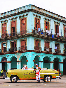 photo man leaning on car in front of building thumbnail