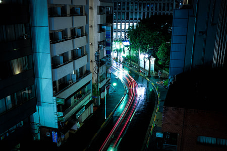 time lapse photography of vehicle on road near buildings thumbnail