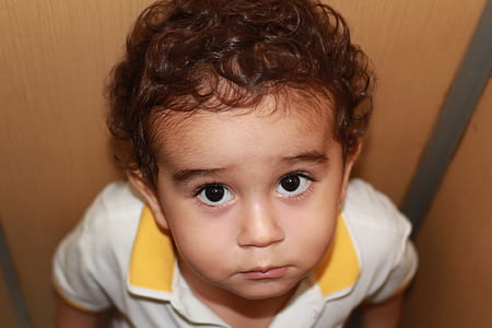 close-up photography of boy in white and yellow polo shirt thumbnail