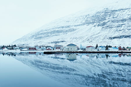 house near body of water and mountain thumbnail