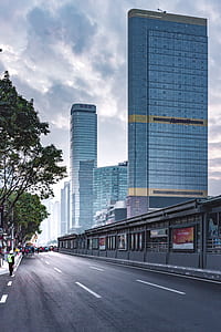 road near trees and high rise buildings at daytime thumbnail