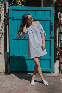 woman standing near blue wooden door thumbnail