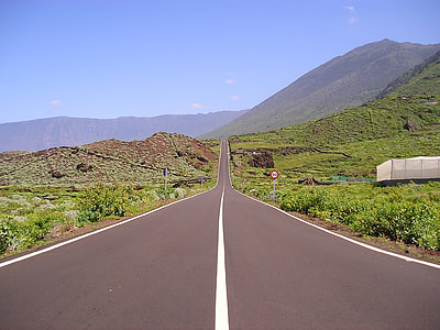 road in between grass fields thumbnail