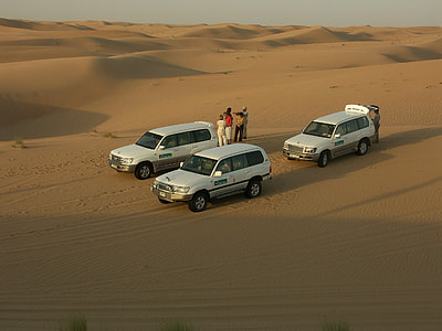 three white SUV's on desert field during daytime thumbnail