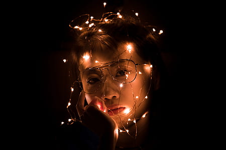 man's face wearing eyeglasses with white string lights all over face thumbnail