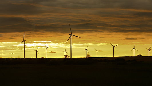 silhouette of wind turbines at sunset thumbnail