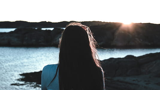 woman wears white shirt near body of water thumbnail