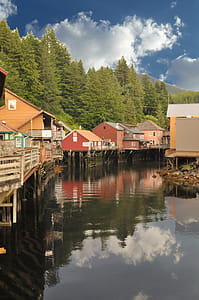 Houses Above Body of Water Under White Clouds thumbnail