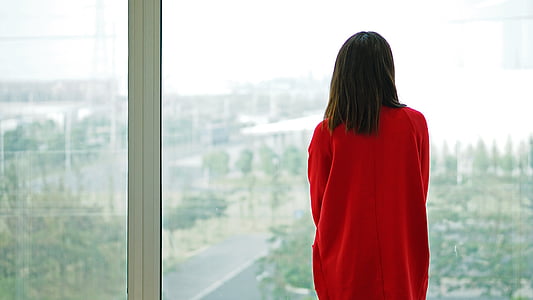woman standing near glass window thumbnail