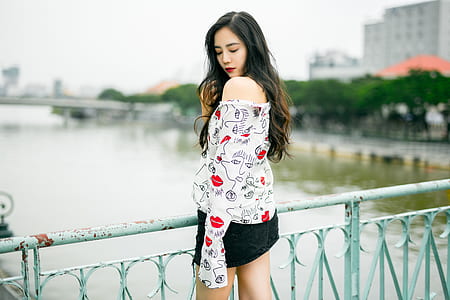 woman standing beside fence during daytime thumbnail