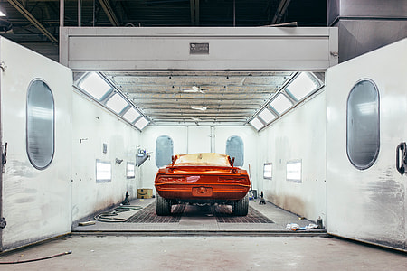 red sports car inside white metal room thumbnail