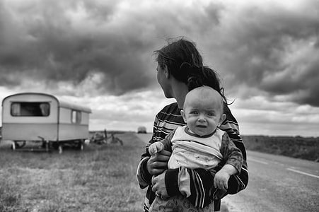 grayscale photography of woman carry child on road thumbnail
