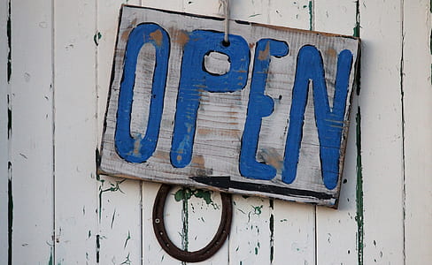 brown and blue wooden Open hanging signboard on white painted wall thumbnail