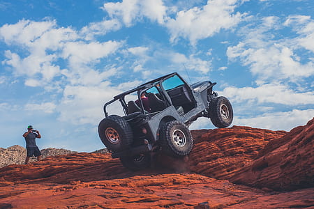 blue Jeep Wrangler on brown rock thumbnail