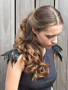woman wearing black sleeveless top with feather thumbnail