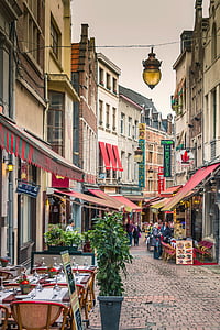 person walking in between buildings during daytime thumbnail