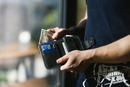 Photograph of Person Holding Black Leather Wallet with Money thumbnail