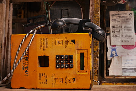 orange payphone near brown metal bar thumbnail