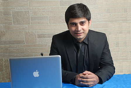 man sitting on chair beside silver MacBook thumbnail