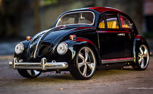 black Volkswagen Beetle parked on sand thumbnail