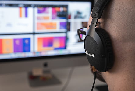 selective focus photography of man wearing Marshal corded headphone close-up photo thumbnail