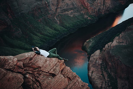 person lying on mountain cliff thumbnail