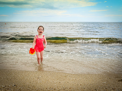 girl laughing while walking on seashore thumbnail