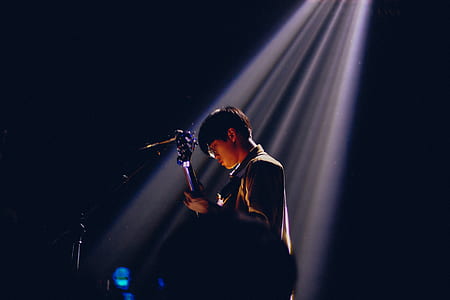 man playing guitar with stage light thumbnail