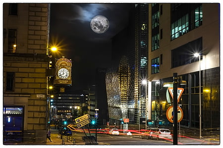 vehicle crossing road near buildings at nighttime thumbnail