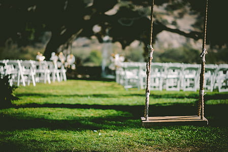 brown wooden base swing near white wooden chairs at daytime thumbnail