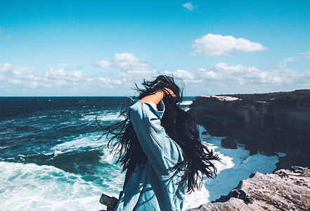 woman standing near cliff and ocean thumbnail