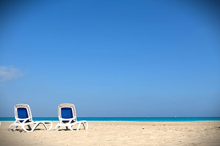 two deckchair on seashore near beach under calming sky thumbnail