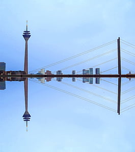 reflecting photo of grey tower beside bridge under blue sky at daytime thumbnail