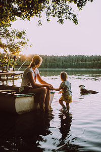 woman holding kid in body of water thumbnail