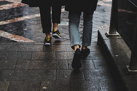 person wearing black sneakers while walking thumbnail