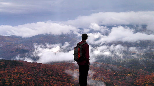 man wearing red long-sleeved shirt standing during daytime thumbnail