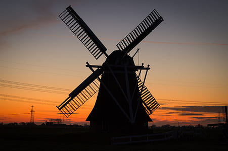 silhouette of windmill under golden hour thumbnail