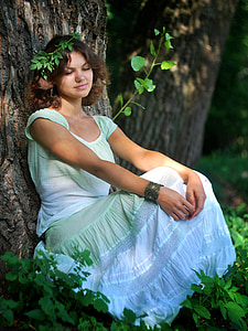 woman in white and green cap-sleeved dress lying on tree thumbnail