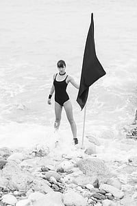 woman holding flag standing on body of water thumbnail
