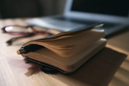 black click pen in between book pages thumbnail