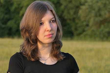woman wearing black top with green trees background thumbnail