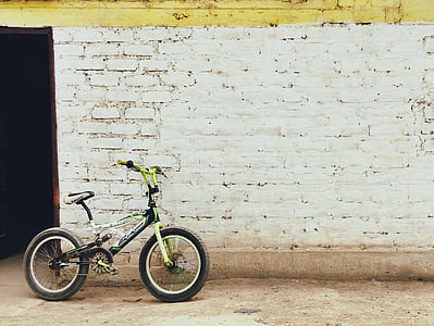 green, white, and black full-suspension bike beside white concrete structure thumbnail
