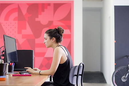 woman in black tank top facing black computer monitor thumbnail