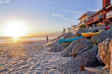 boy standing on stair near shore under the sunrise thumbnail