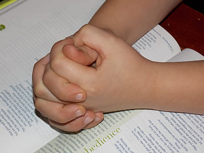 person's hand on book thumbnail