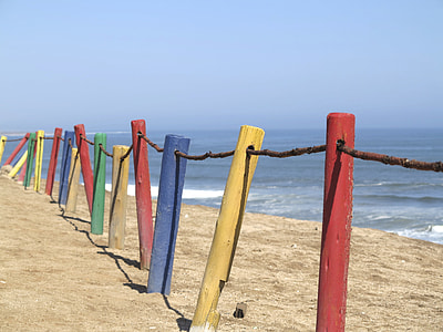 red, yellow, and blue fence near sea thumbnail