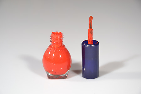 orange nail polish bottle on white surface thumbnail
