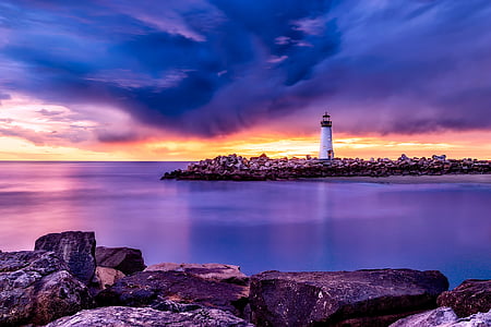 white lighthouse surrounded by body of water during golden hour painting thumbnail